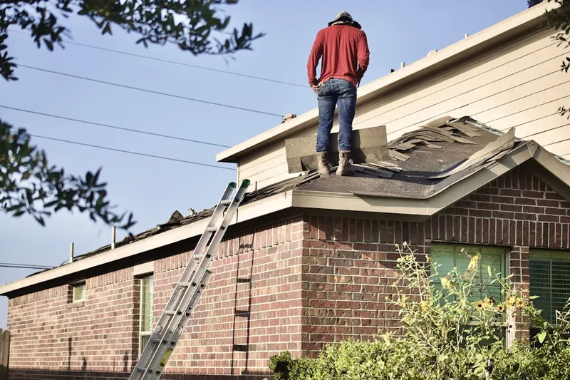 Professional roofer working on a residential roof in East Bend